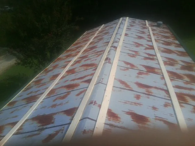Rusted metal roof panels with new wood purlins before replacement — Storm Damage Roof Repair in Evadale by Roofing Brothers